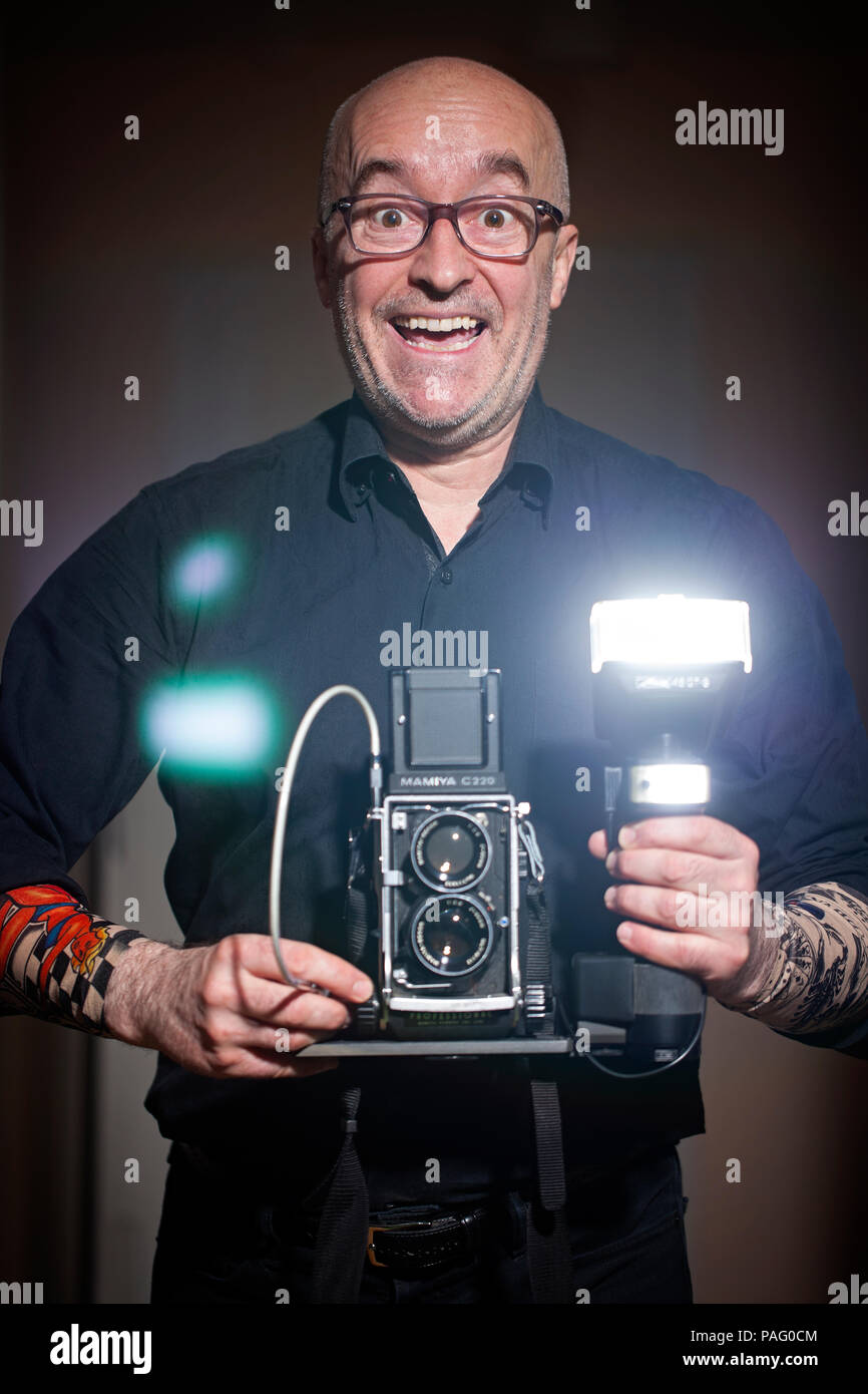 Selbstportrait des Fotografen holding Film Kamera Mamiya C220 mit Blitz Metz 45 CT-5. 45, 50, 55, 60 Jahre alt. Manhattan, New York City, USA Stockfoto