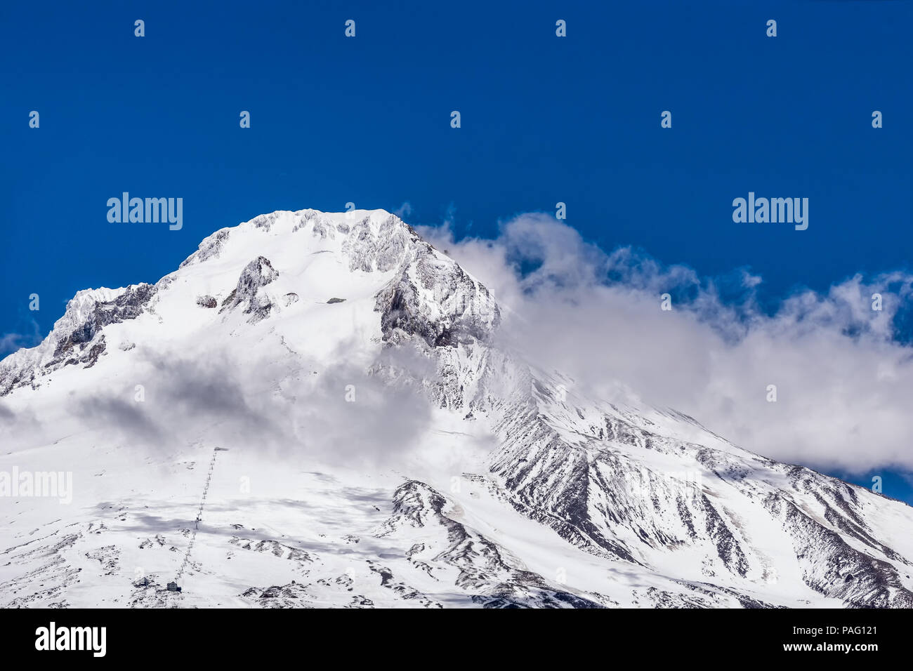 Nahaufnahme der verschneiten Südhang und Gipfel des Mount Hood mit Wolken und blauer Himmel an einem schönen Tag, Oregon, USA. Stockfoto