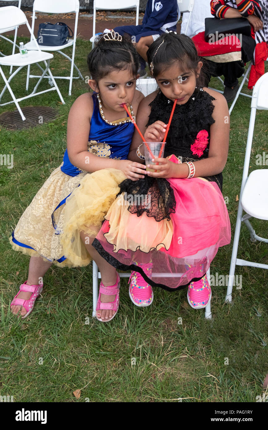 Cute Sikh Schwestern teilen ein kaltes Getränk an einem Sommertag in der Sikh Gurmat Spiele an Smokey Park in South Richmond Hill, Queens, New York. Stockfoto