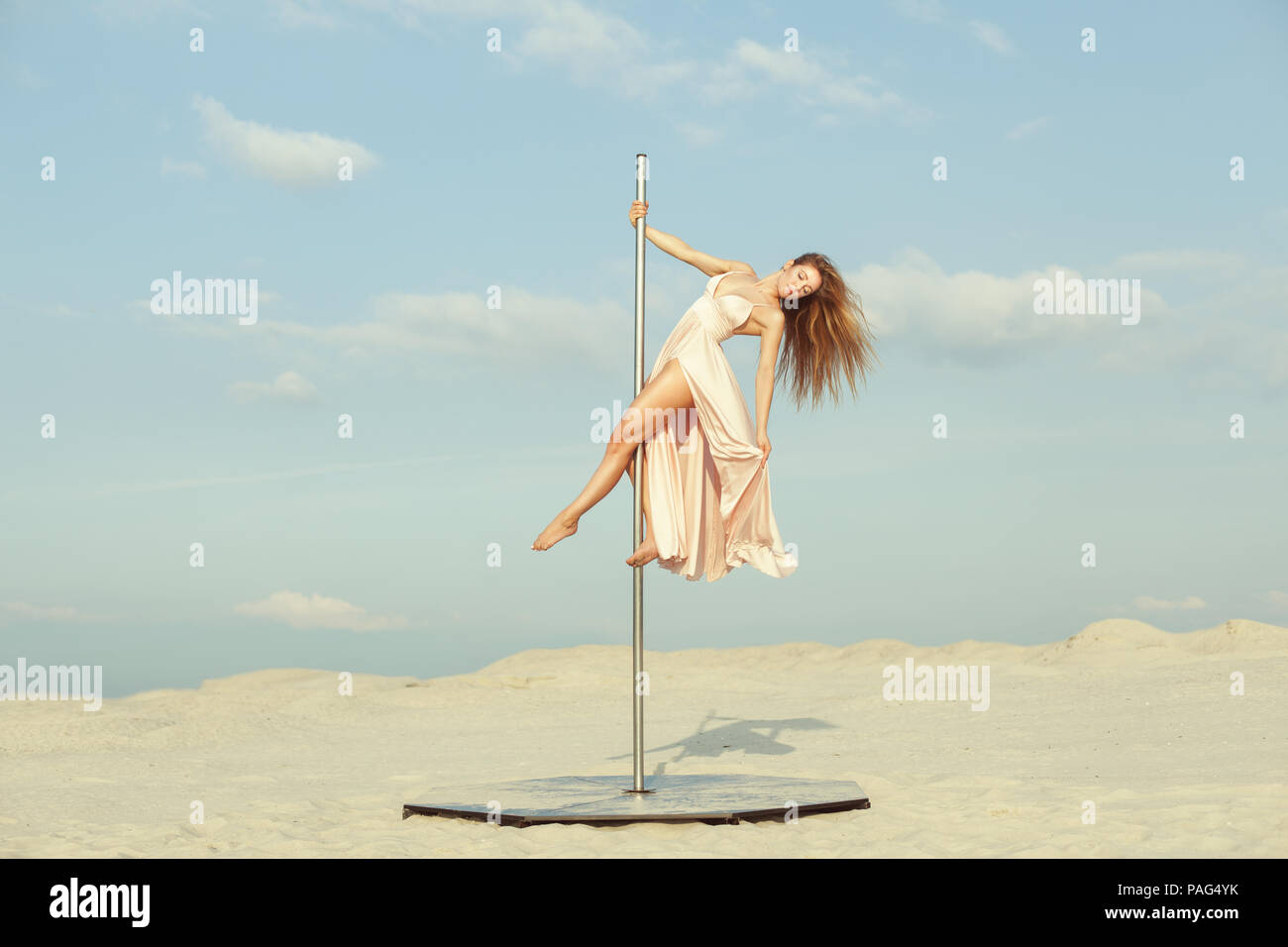 Schöne Frau in einem Kleid Tanz auf dem Pylon in der Wüste. Stockfoto