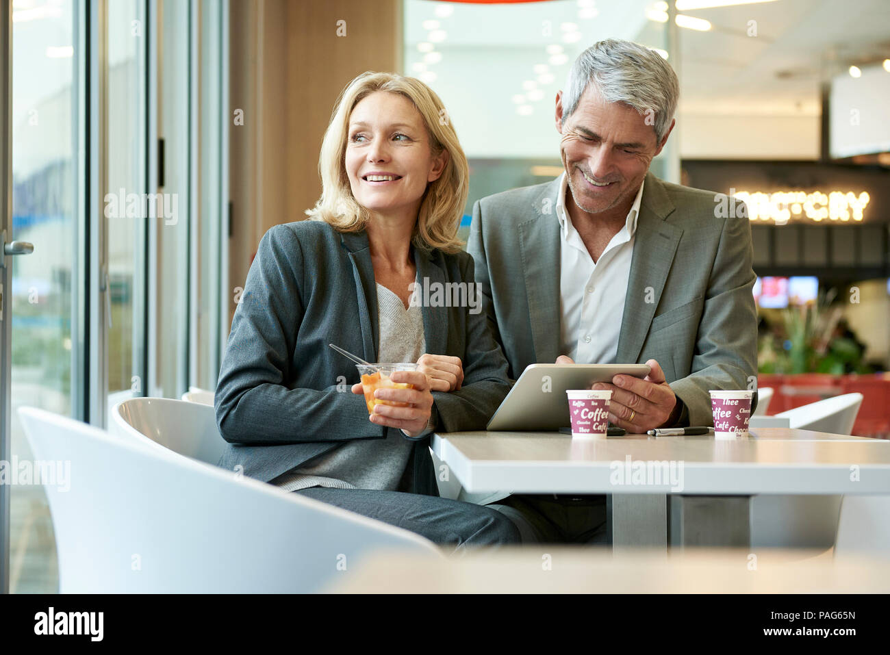 Geschäftsleute, die sich mit digitalen Tablet in der Cafeteria Stockfoto
