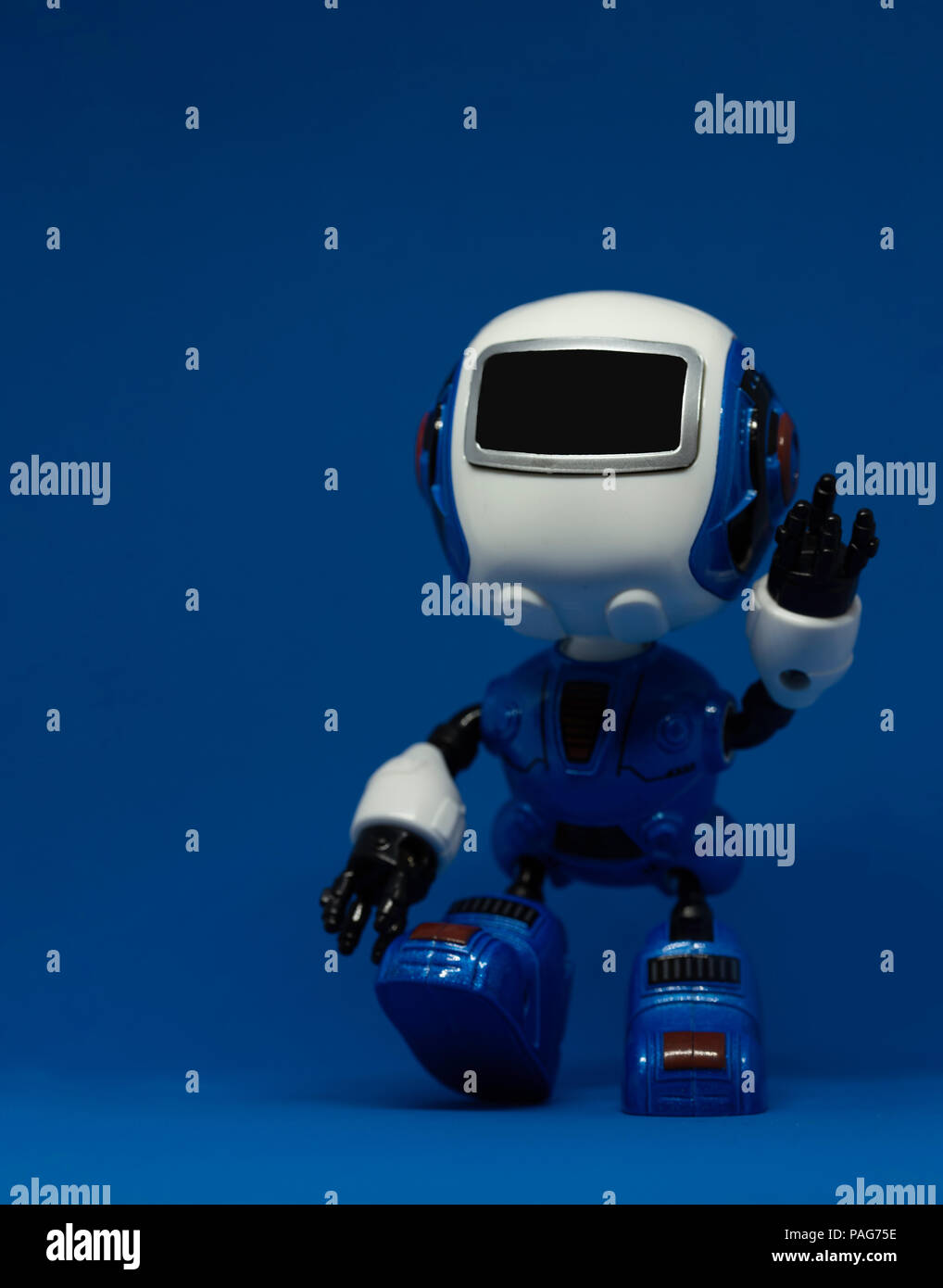 Roboter Spielzeug winken Linken auf blauem Hintergrund Stockfoto