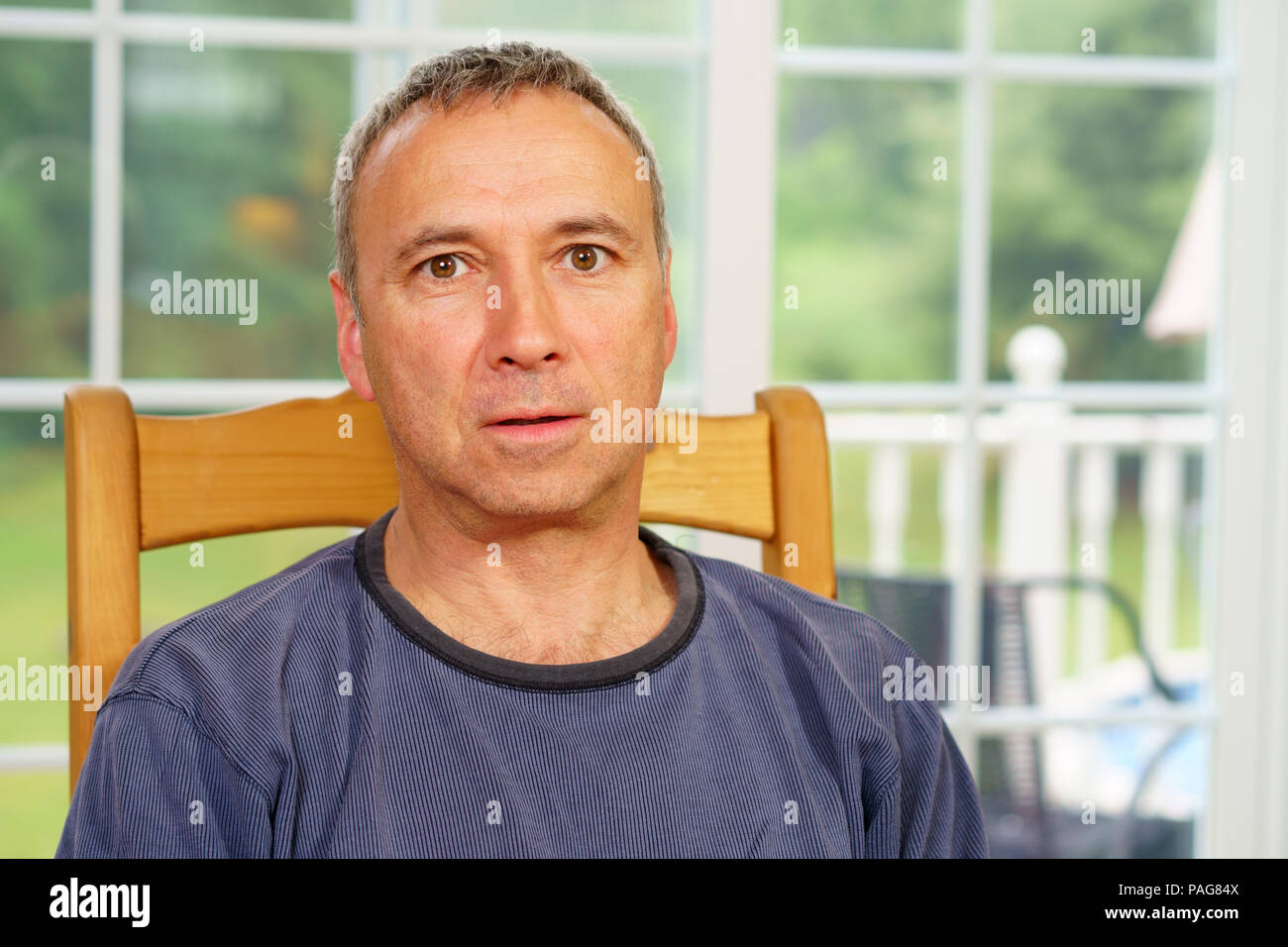 Kaukasische Mann, Allein, sitzen an einem Tisch, Tag, Sorgen oder selbst Befragung. Poker Face. Stockfoto