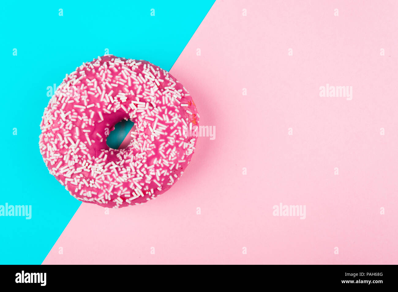Ein rosa isoliert Donut auf einer Münze und rosa Hintergrund Stockfoto