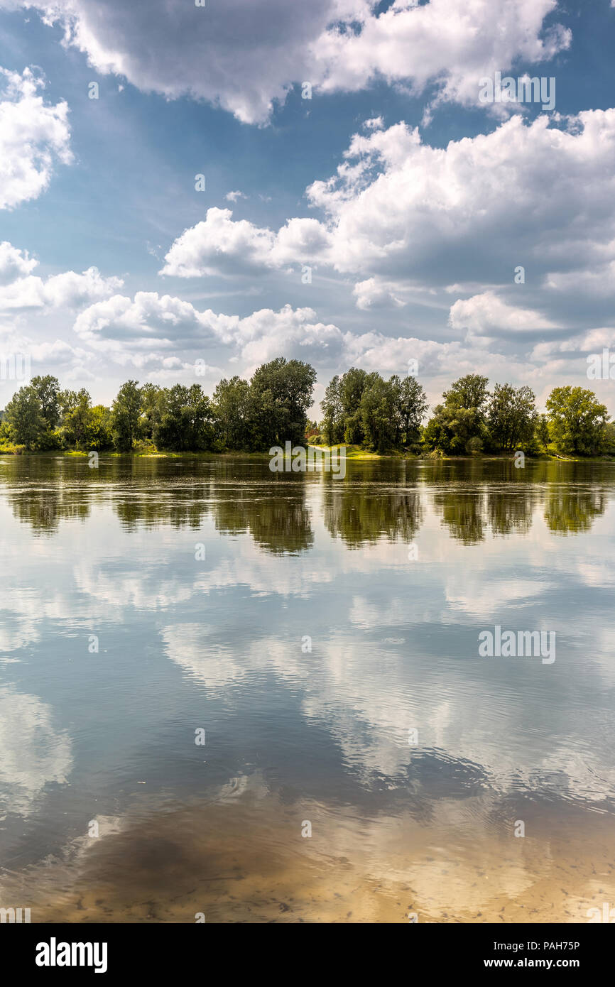 Faul Sommer Tag am Fluss. Linie der Bäume am gegenüber Bank macht Symmetrie Stockfoto