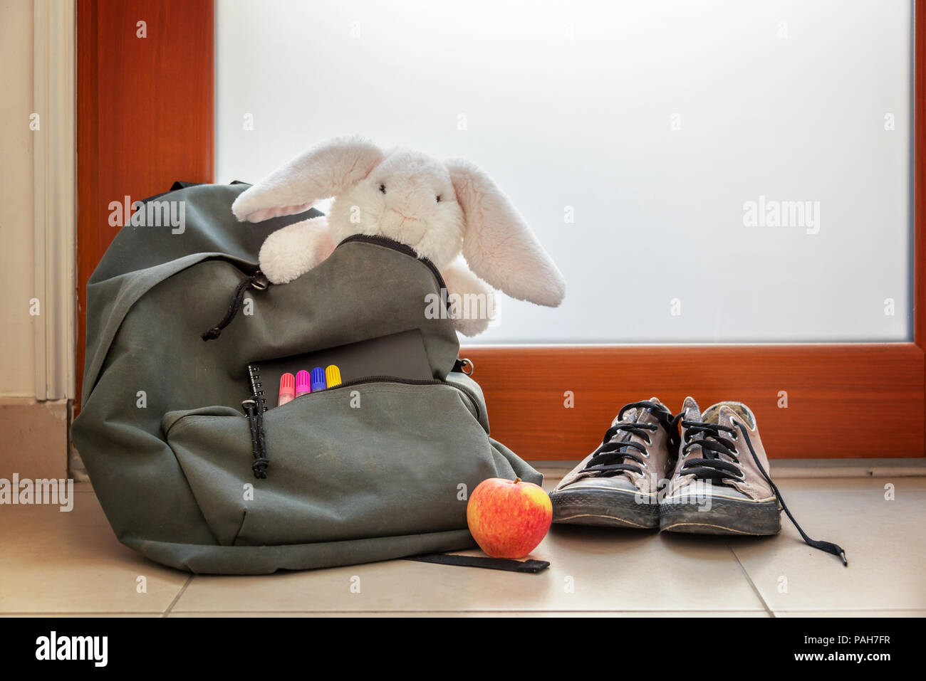 Schuhe und Schultasche mit Kuscheltier, Zubehör und Mittagessen Stockfoto