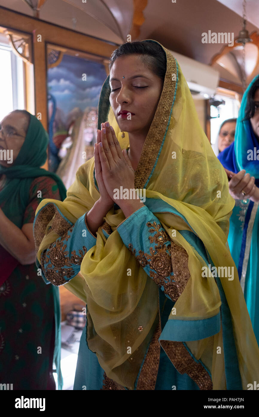 Ein Hindu Frau in Gebet und Meditation zu einem Mandir (Hindu Tempel in South Ozone Park, Queens, New York. Stockfoto