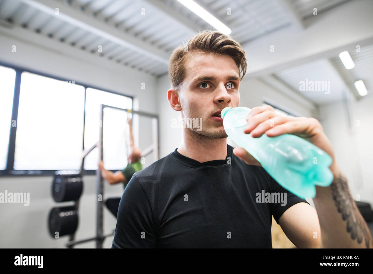 Der Mensch in der Turnhalle in zwischen Übungen, Trinkwasser. Stockfoto