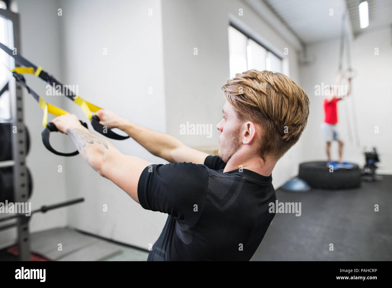 Passen junge Mann im Fitnessstudio arbeiten mit Federung Trägern. Stockfoto