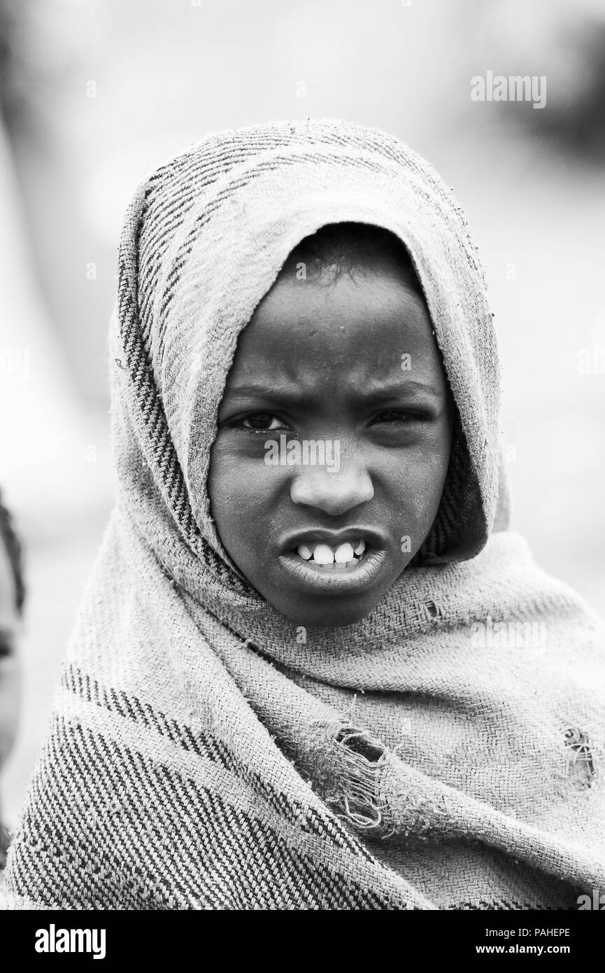 OMO VALLEY, Äthiopien - Sep 22, 2011: Unbekannter äthiopischen Mädchens durch warme Kleidung in Äthiopien, 22.09.2011. Menschen in Äthiopien leiden von Pover Stockfoto