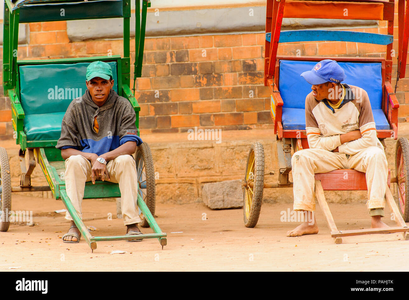 ANTANANARIVO, Madagaskar - 29. JUNI 2011: Unbekannter Madagaskar Jungen auf einem Schlitten sitzen. Menschen in Madagaskar Leiden der Armut aufgrund der langsamen devel Stockfoto
