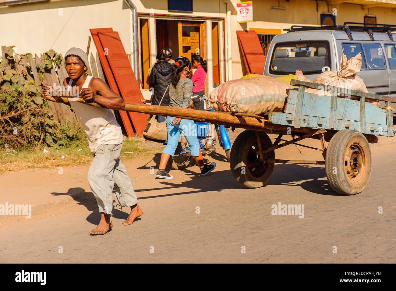 ANTANANARIVO, Madagaskar - 29. JUNI 2011: Unbekannter Madagaskar Mann trägt eine Beförderung Beförderung mit Taschen. Menschen in Madagaskar Leiden von Pover Stockfoto