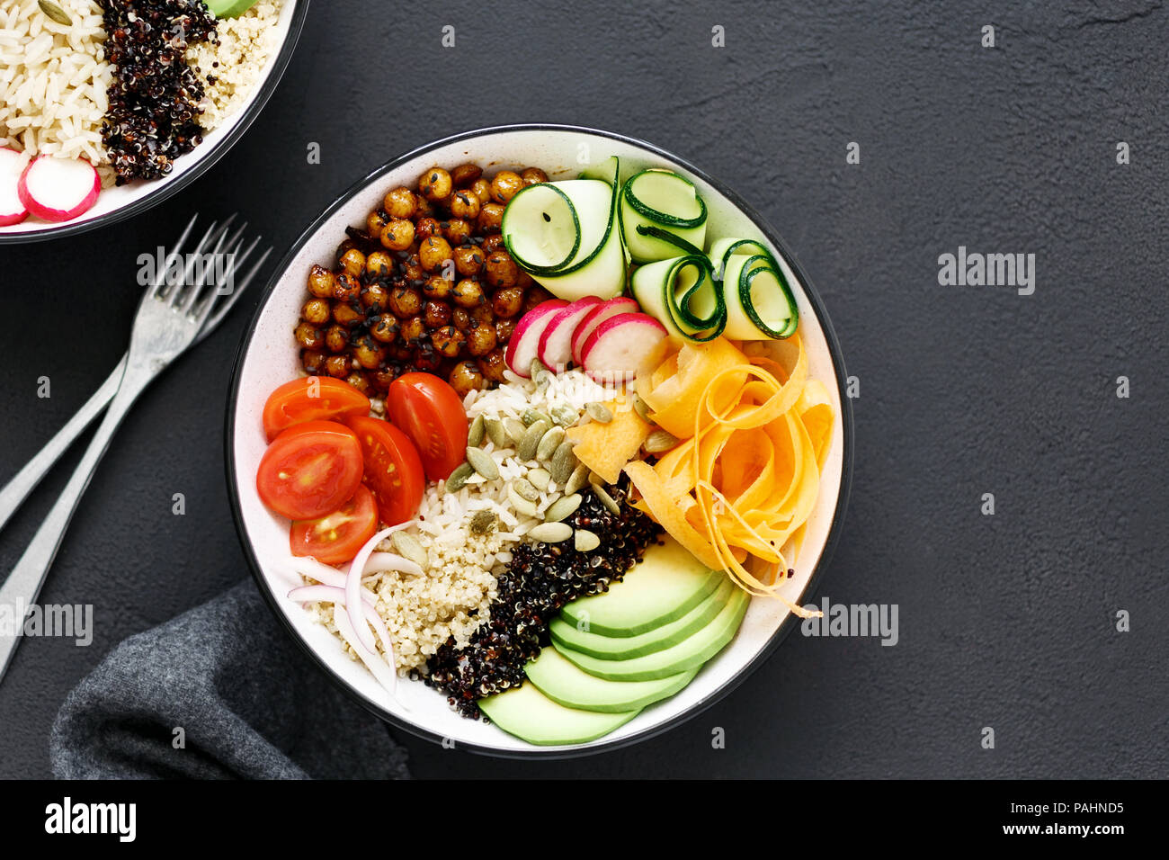 Sauber und gesund Gesunde Ernährung Konzept. Zwei vegetarische Buddha Schüssel. Reis, würzige Kichererbsen, schwarze und weiße Quinoa, Avocado, Karotten, Zucchini, Rettich, Stockfoto