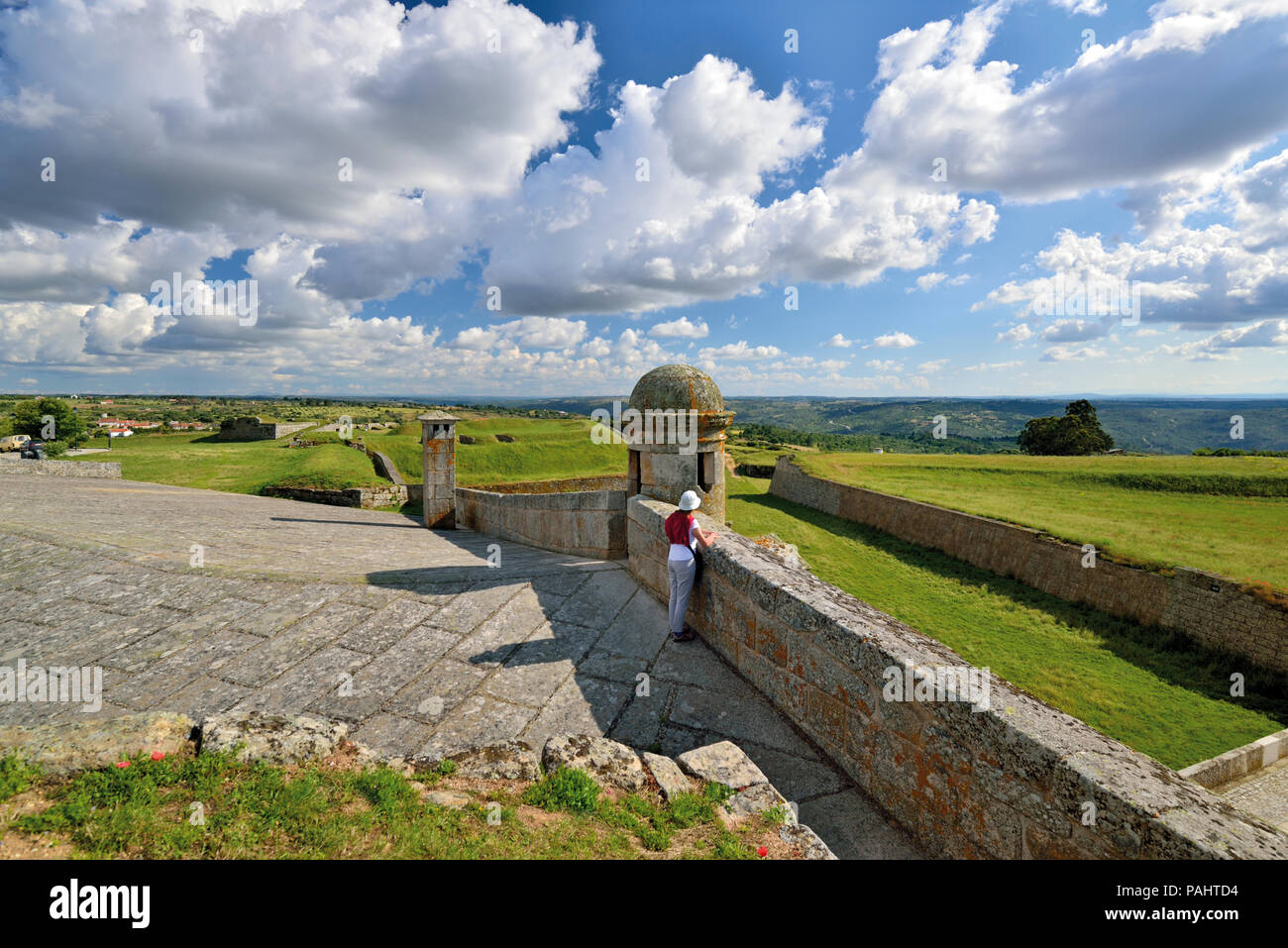 Frau genießen Aussicht von der Burg Wände über eine weite grüne Land und dramatische ziehenden Wolken Stockfoto