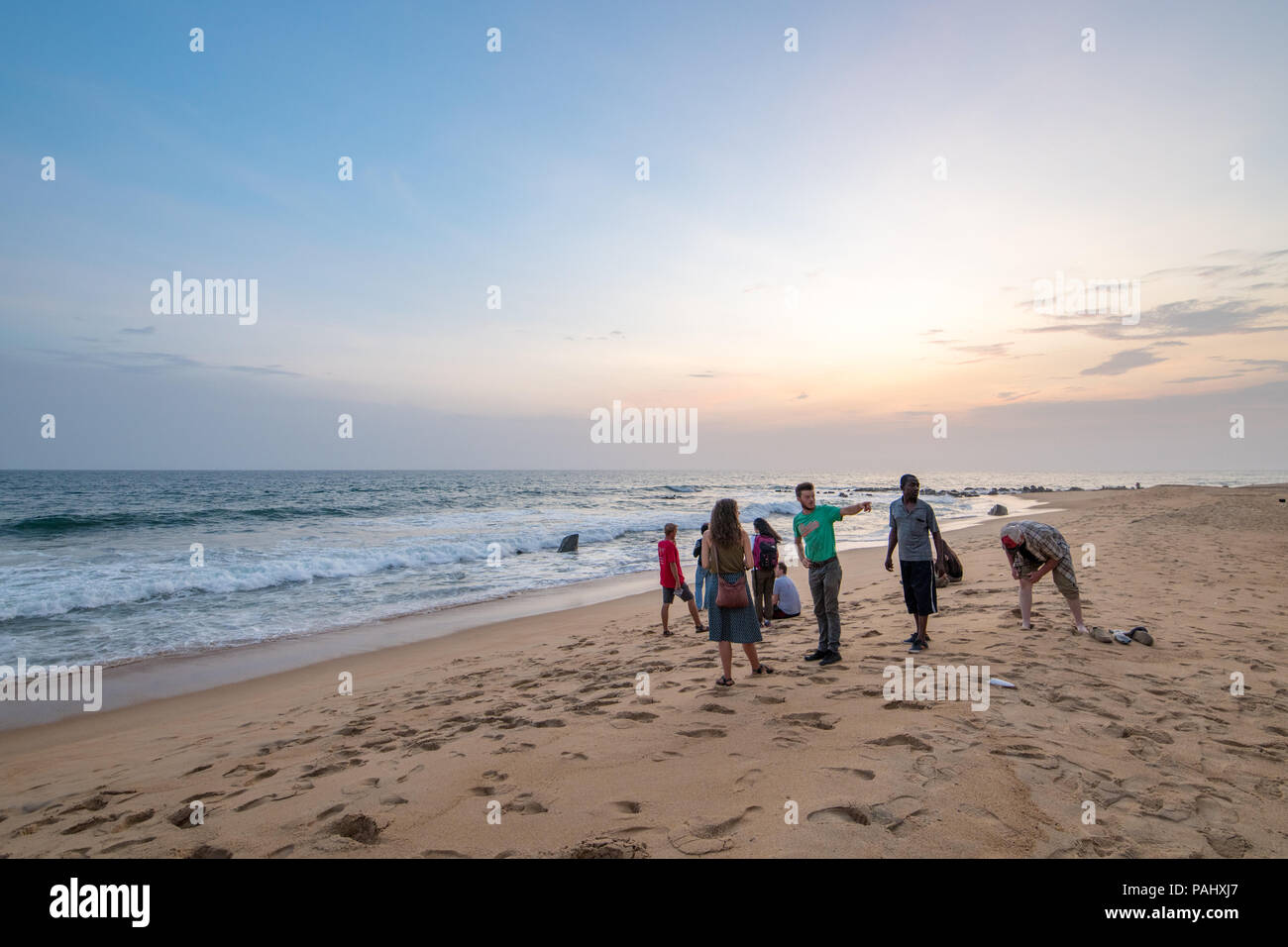 Eine Gruppe von Menschen Treffpunkt auf dem Strand in die Wellen Monrovia, Liberia suchen Stockfoto