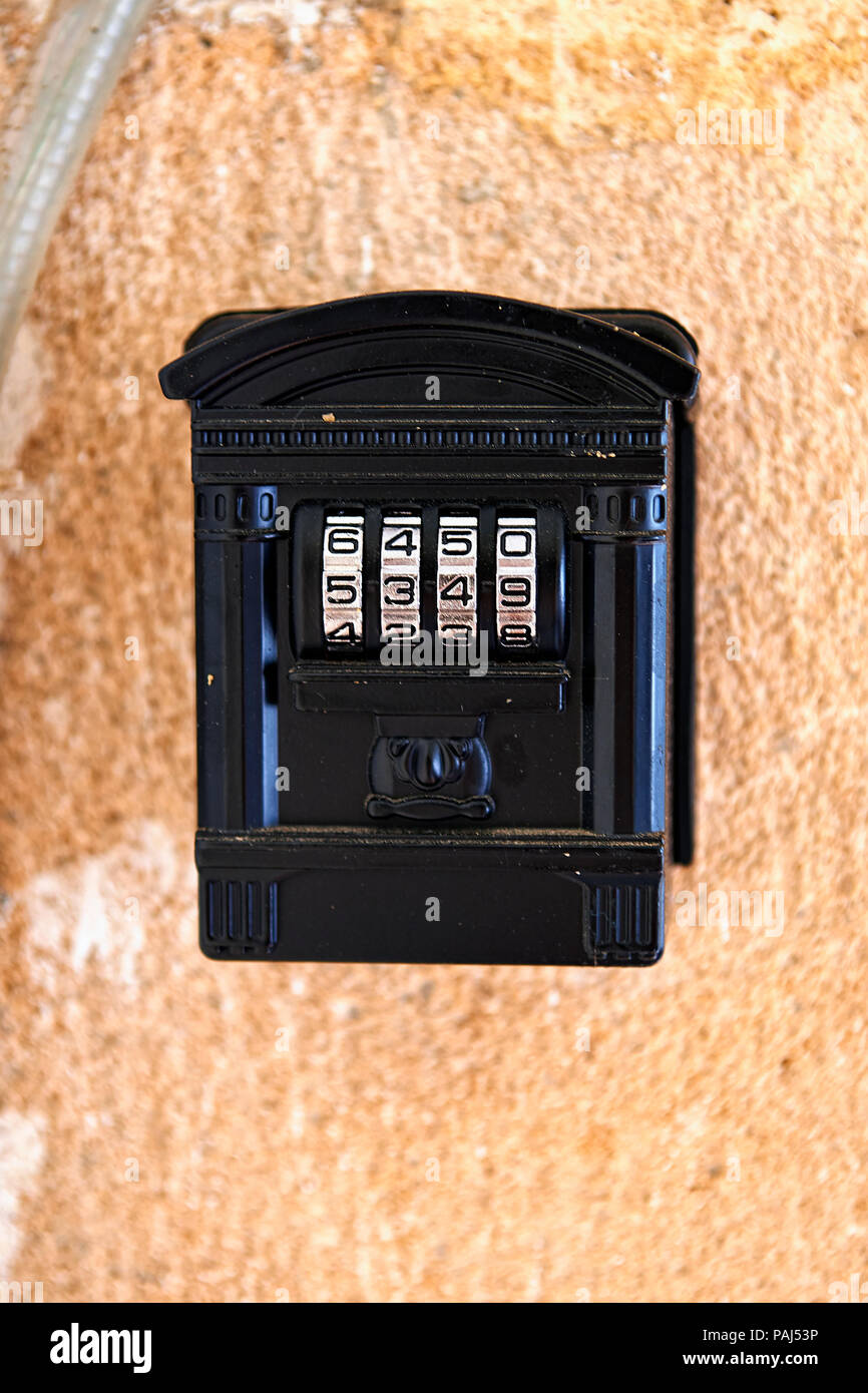 Alten Code Vorhängeschloss im Haus Form auf texturierte Wand Stockfoto