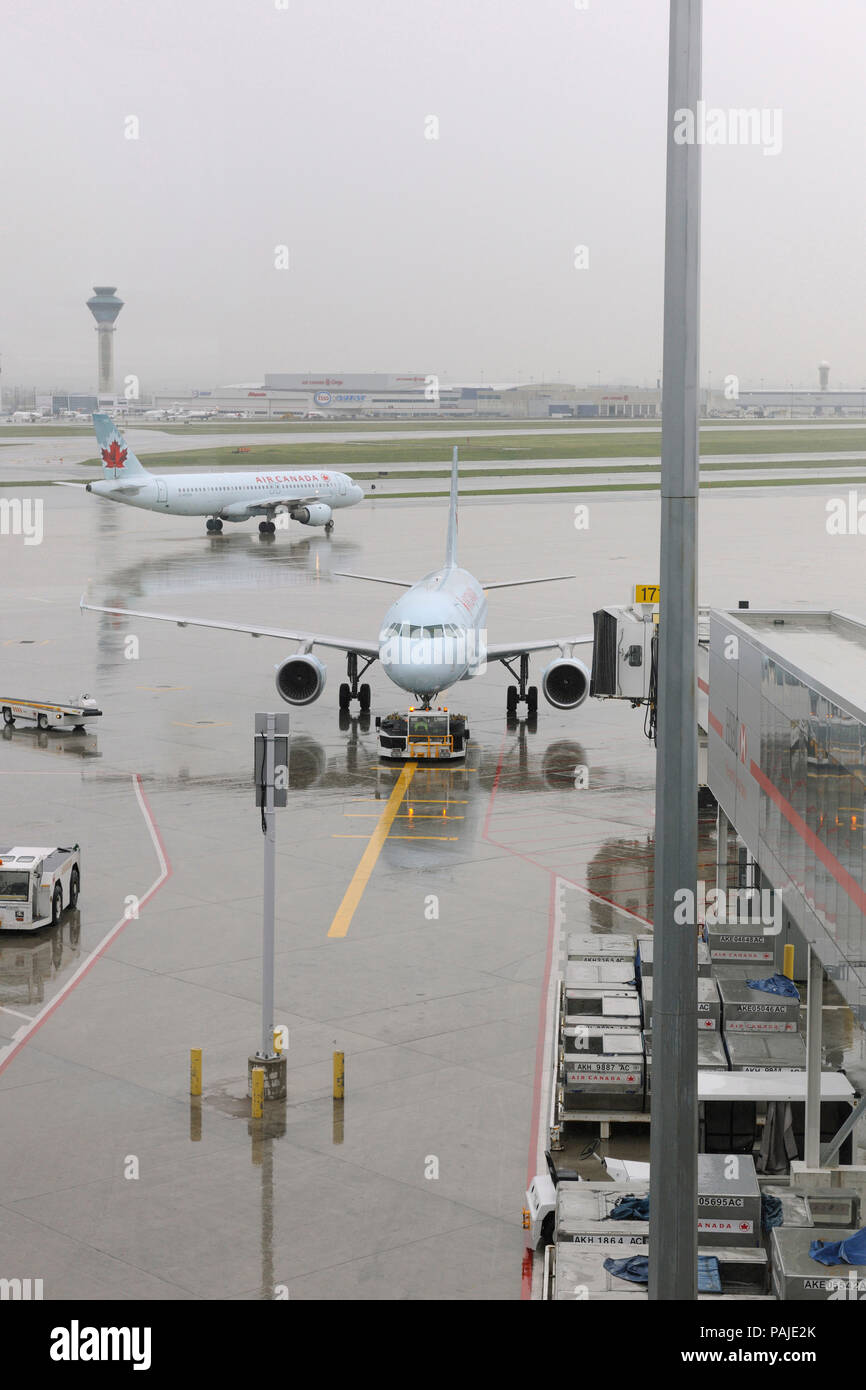 Air Canada Airbus A319 - zurück von einem Schlepper geschoben, A319 rollt mit der Flugsicherung - Tower hinter Stockfoto