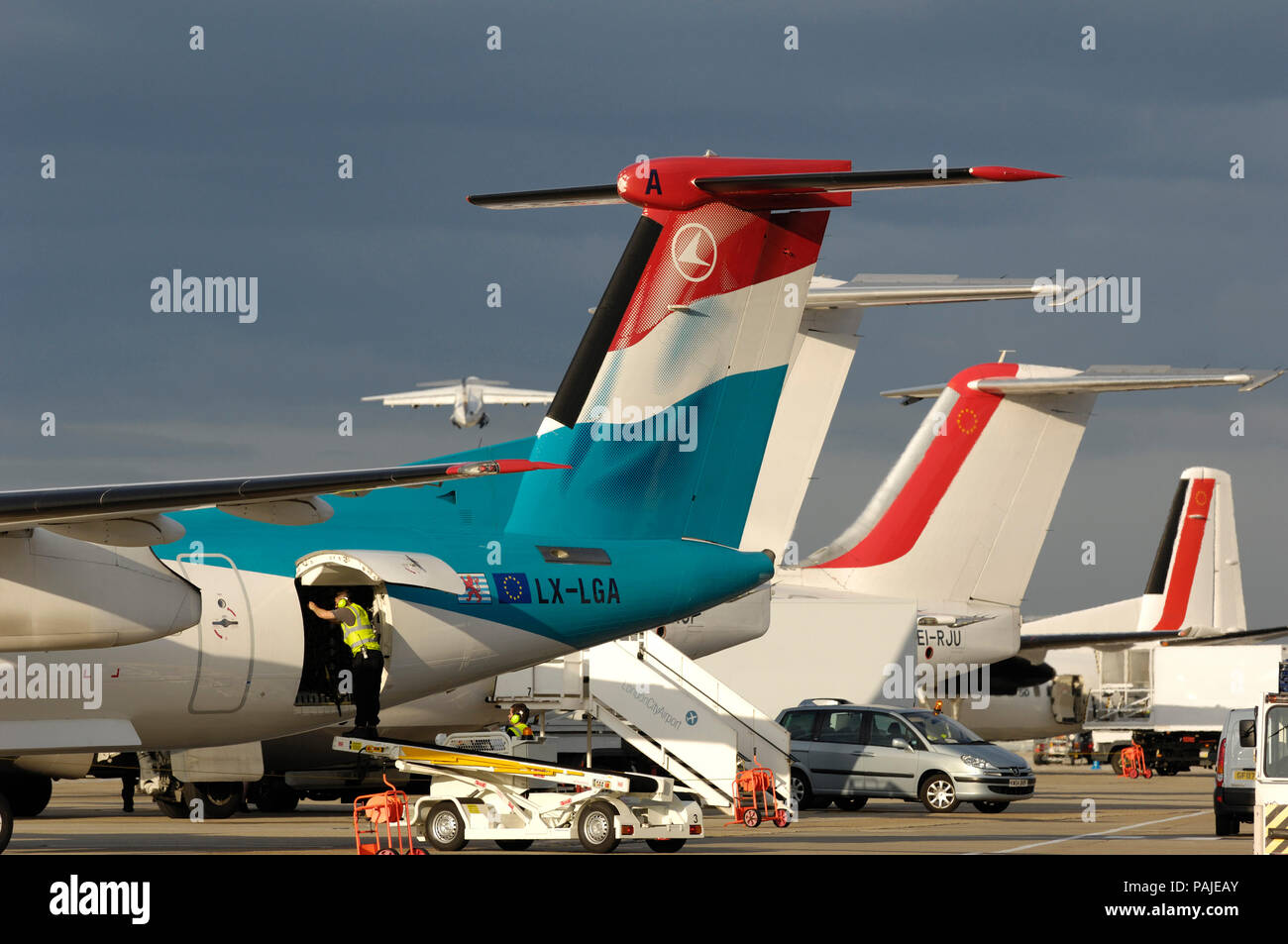 Schwanz-Flossen von Luxair Bombardier DHC-8 Dash 8-400 Q400 mit CityJet BAE 146 s und Fokker F-50 in London Stadt geparkt Stockfoto