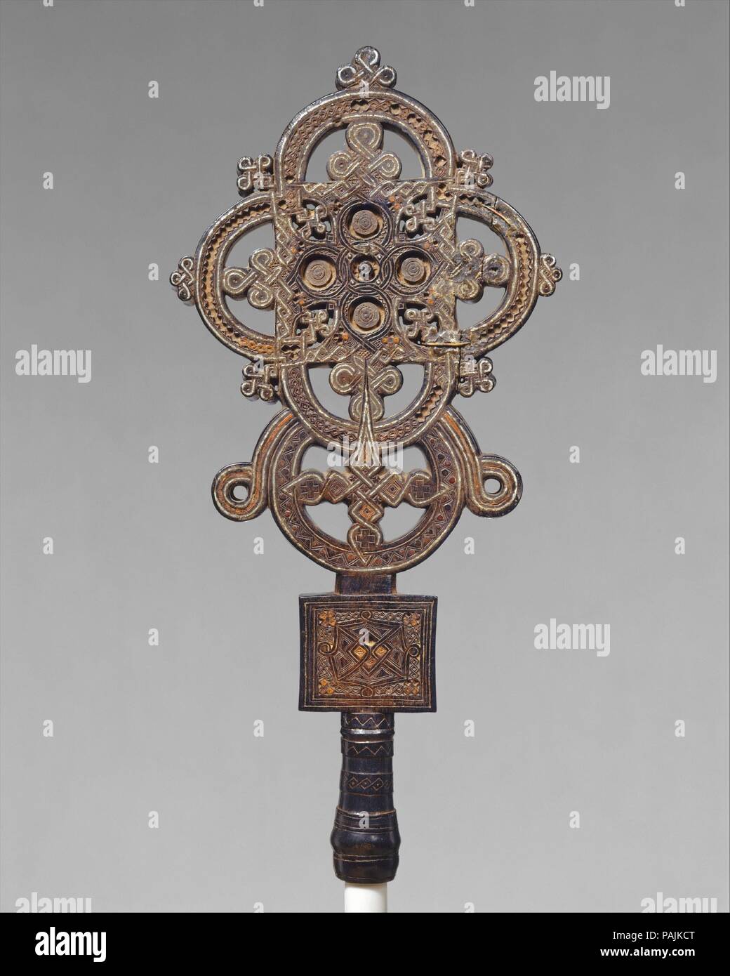 Vortragekreuz. Artist: Esra. Kultur: Tigrinya Völker. Abmessungen: H 18 x W 17. (45,7 x 43,2 cm). Datum: Ca. 1500. Dieses Kreuz wurde in der Provinz Tigray erstellt, in der Nähe des Roten Meeres, der Wiege der frühesten Äthiopiens Königreich und des Christentums in Afrika. Ein kleines Korpus der Äthiopischen christlichen Werke aus dem siebzehnten Jahrhundert überlebt hat. Dieser außergewöhnlichen Schöpfung, in der ein sehr ungewöhnliches Zusammenspiel von Materialien bietet reiche tonale Kontraste, ist eine Tour de force. Die Solidität der geschnitzten Holz Struktur ist durchdrungen von Fein angewandte Metall Inlays. Die Komplexität der Stockfoto