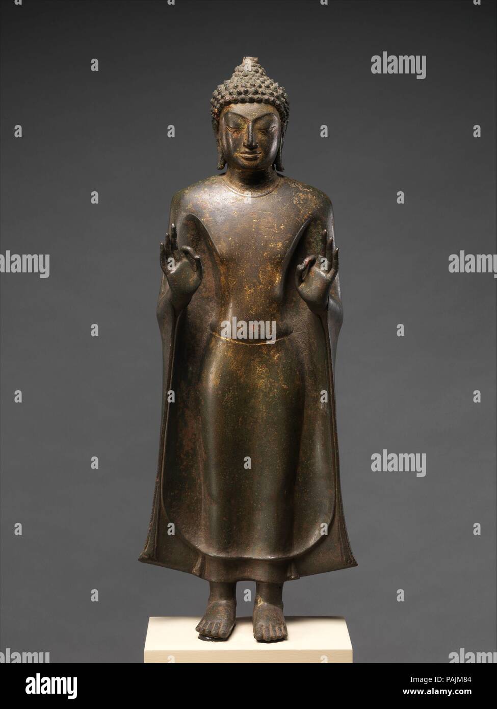 Stehender Buddha. Kultur: Thailand (Nakhon Pathom Provinz). Abmessungen: H.27. (68,6 cm); W. 10 1/4 in. (26 cm); D.5 3/8 in. (13,7 cm). Datum: 8. bis 9. Jahrhundert. Erhebliche Innovationen in religiösen Ikonographie wurden während der Mon-Dvaravati Zeitraum entwickelt. Zum Beispiel, viele Buddhas halten Sie Ihre beiden Hände in einer Geste der Exposition oder Lehre (vitarkamudra), die in Indien zur Rechten beschränkt ist. Bilder von der Seite von Prakhon Chai zeigen auch diese doppelte Handbewegung, aber ansonsten Es ist unbekannt, in der buddhistischen Welt. Weitere ikonographische Innovation war ein Stand zu setzen Stockfoto