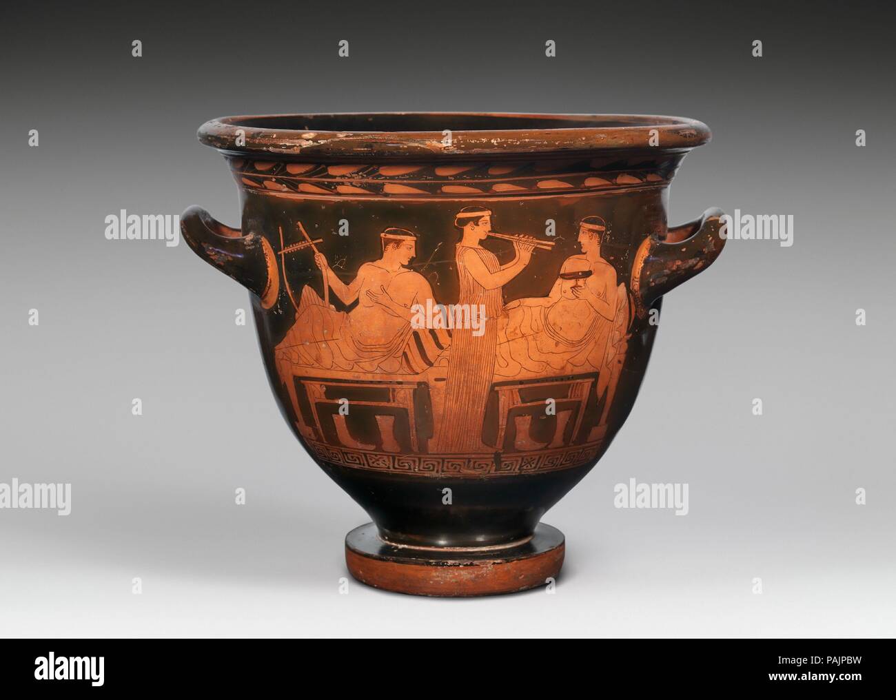 Terrakotta bell-Krater (Schüssel für das Mischen von Wein und Wasser). Kultur: Griechisch, Dachboden. Abmessungen: Andere: 13 1/4 x 16 in. (33,7 × 40,6 cm) Durchmesser: 15×6 1/4 in. (38,1 × 15,9 cm). Datum: Mitte des fünften Jahrhunderts v. Chr.. Mit nur drei Figuren und sorgfältig ausgewählt und wiedergegeben - Musikinstrumente, die Trinkbecher, die Stiefel auf den Boden, die Darstellung erfasst und charakterisiert eine klassische Symposium. Die Szene ist bemerkenswert für seine Schwerkraft. Museum: Metropolitan Museum of Art, New York, USA. Stockfoto