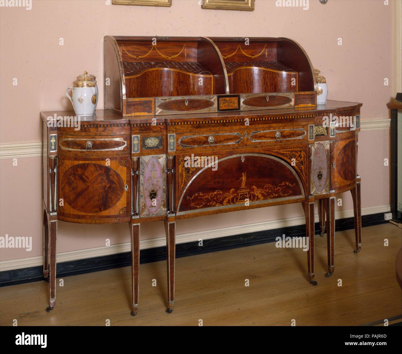Sideboard. Kultur: American. Abmessungen: 65 x 89 x 31 in. (166.4 x 226.1 x 78.7 cm). Datum: Ca. 1795-1805. Unbekannt in amerikanische Häuser vor den 1790s, das Sideboard wurde schnell ein wesentlicher Bestandteil der modernen Speisesaal. Es bot Platz für die Speicherung und Anzeige von teuren Silber Besteck, Porzellan und Glaswaren während einer Mahlzeit benutzt. Diese massive und strahlend Beispiel mit einem begleitenden Messer Box ist eine Tour de force des frühen neunzehnten Jahrhunderts Tischlerei. Es verfügt über eine einzigartige Vielfalt an Ornament, von eingelegten platten aus mahagoni Furnier, Intarsien, ein Stockfoto