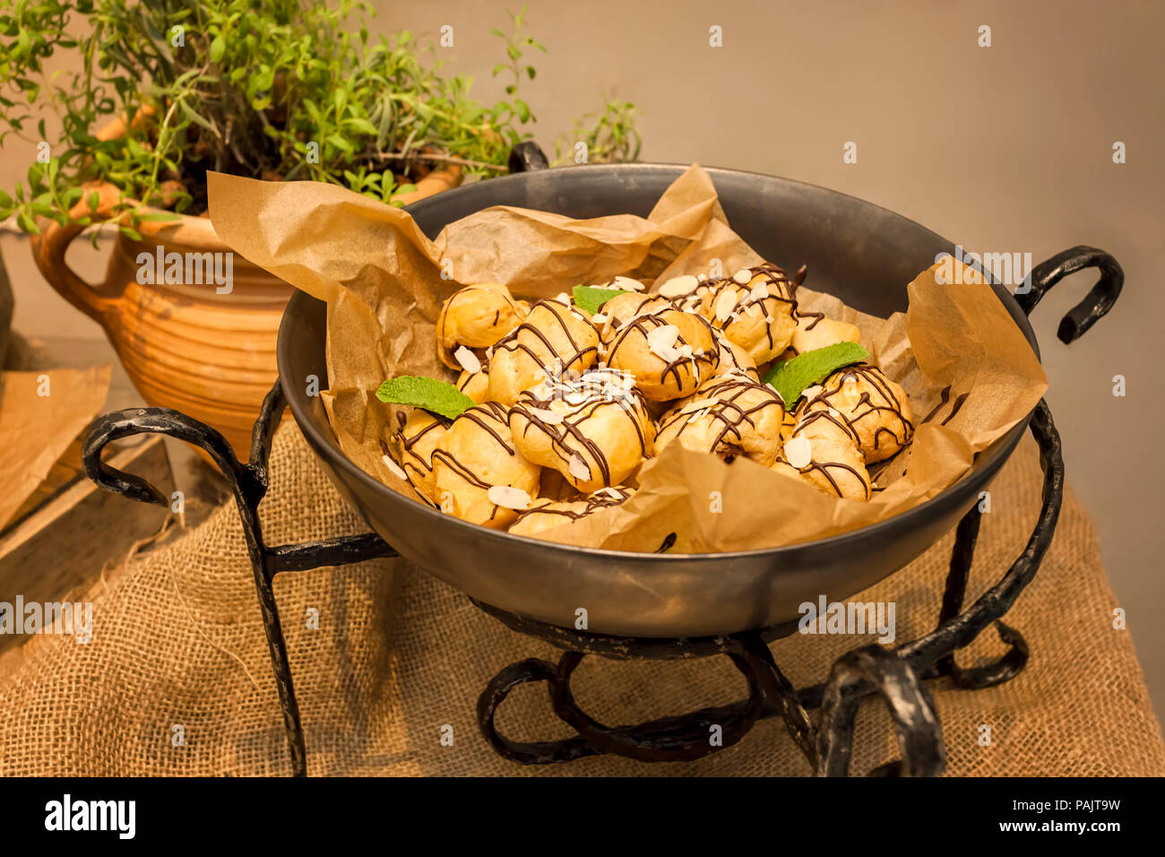 Windbeutel Dessert mit Sahne und Schokolade Glasur auf einer Platte im Restaurant serviert. Stockfoto