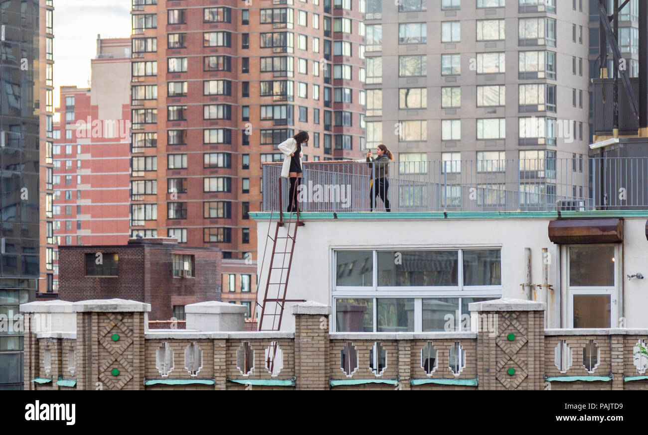Zwei Frauen auf dem Dach eines New Yorker Gebäude selfies unter Stockfoto