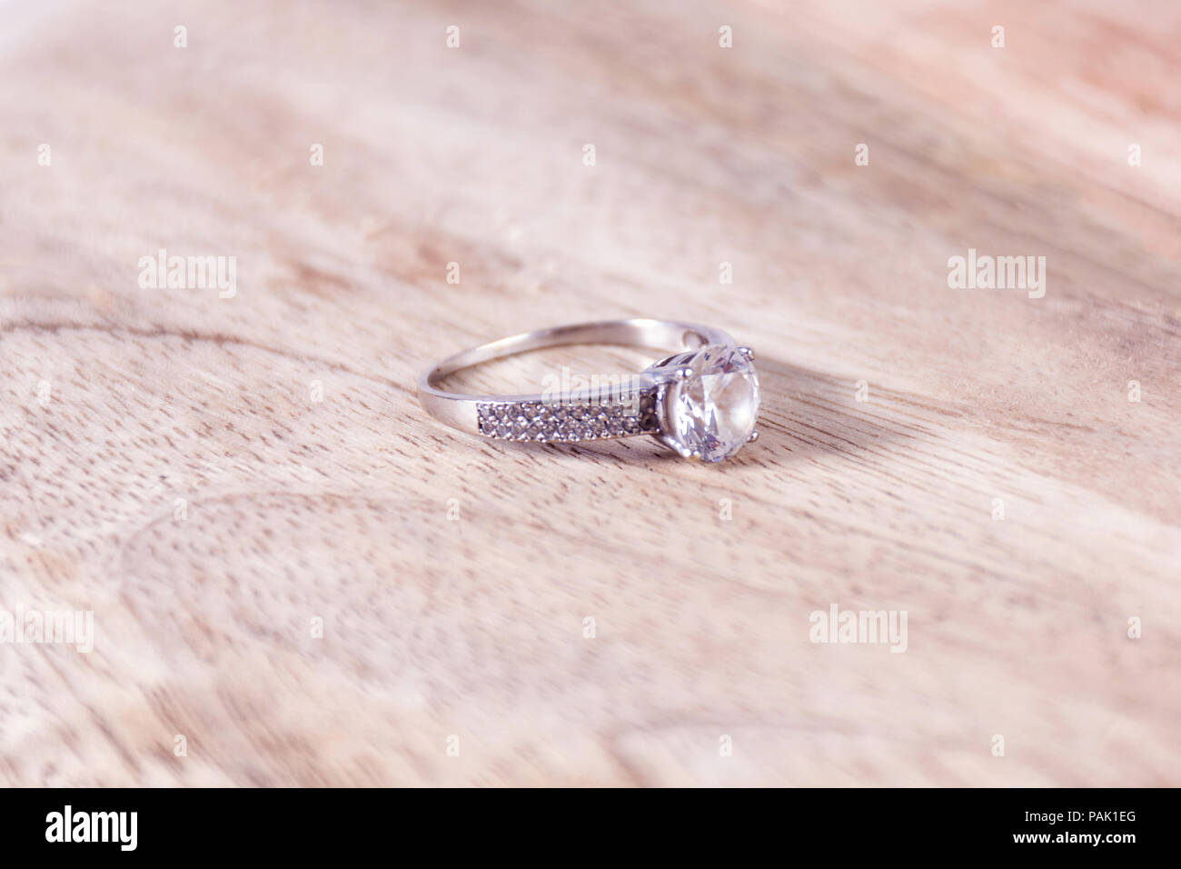 Schöne Hochzeit Hintergrund mit Diamant Verlobung Hochzeit Ring auf hölzernen verschwommen und weichem Hintergrund im Studio. Liebe und heiratete Konzept Stockfoto