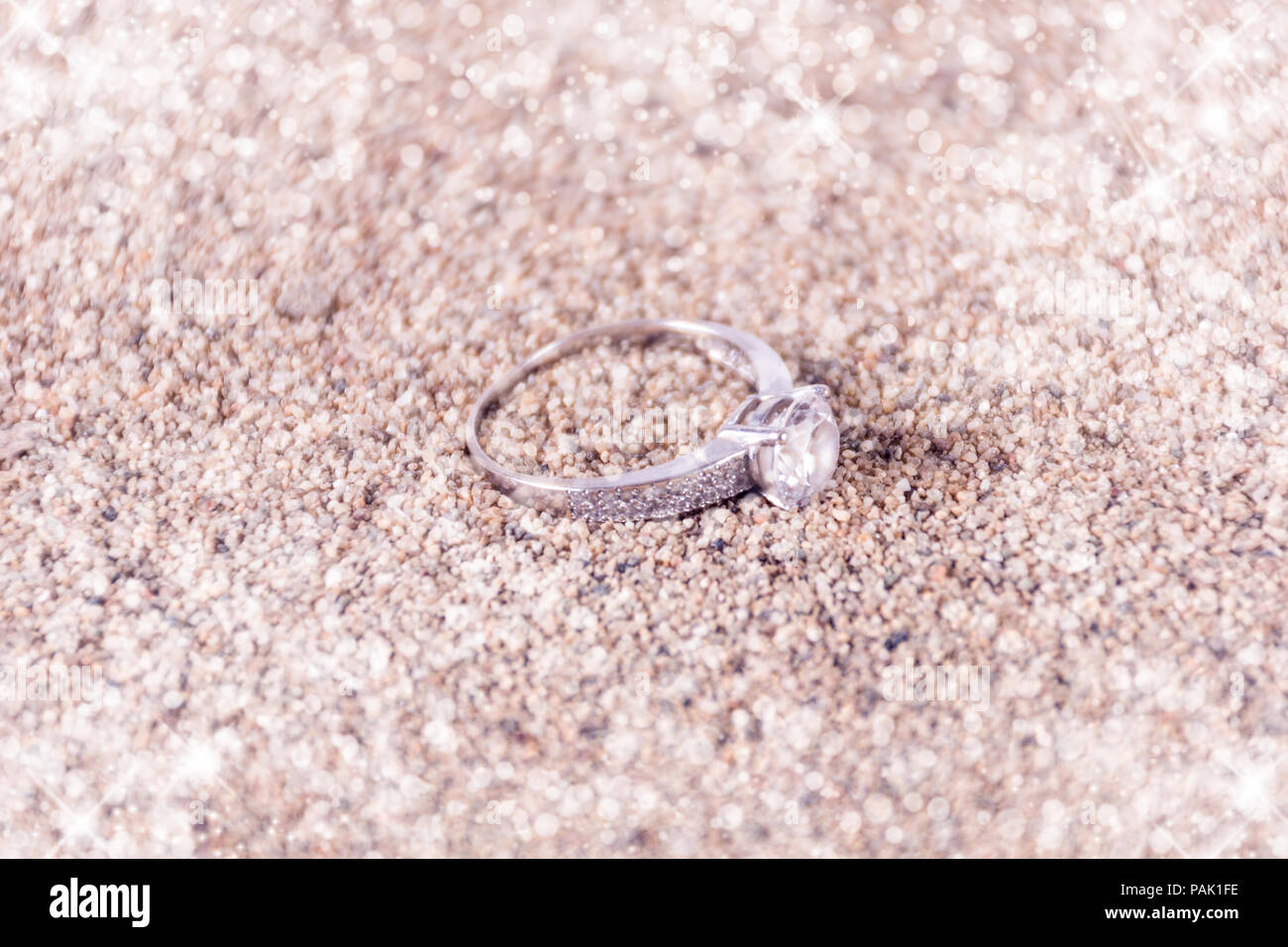 Designer silber Trauringe auf Sand und funkelnden Glitter soft und unscharfen Hintergrund und Platz für Text. Liebe und heiratete Konzept Stockfoto
