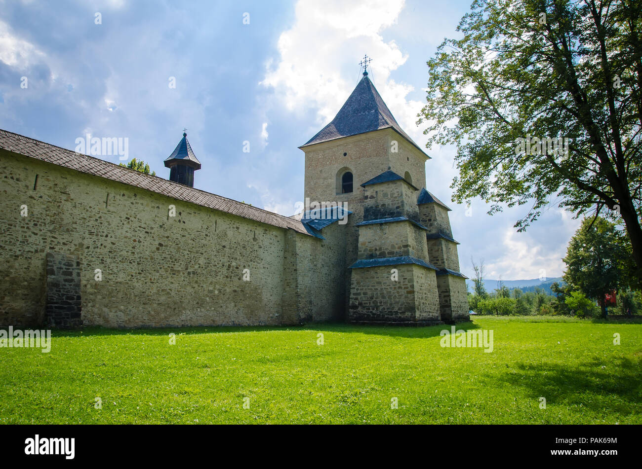 Alte Rumänische mittelalterlichen Kloster Festungsanlage mit Steinmauer und Turm in Moldawien Region an einem sonnigen Sommertag mit grünem Gras und blauen bewölkten Himmel Stockfoto