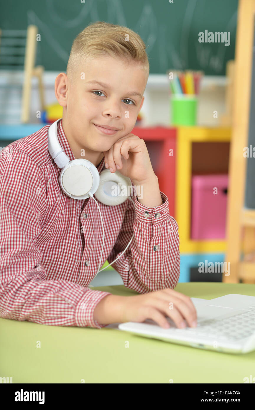 Junge mit Kopfhörern über Laptop Stockfoto