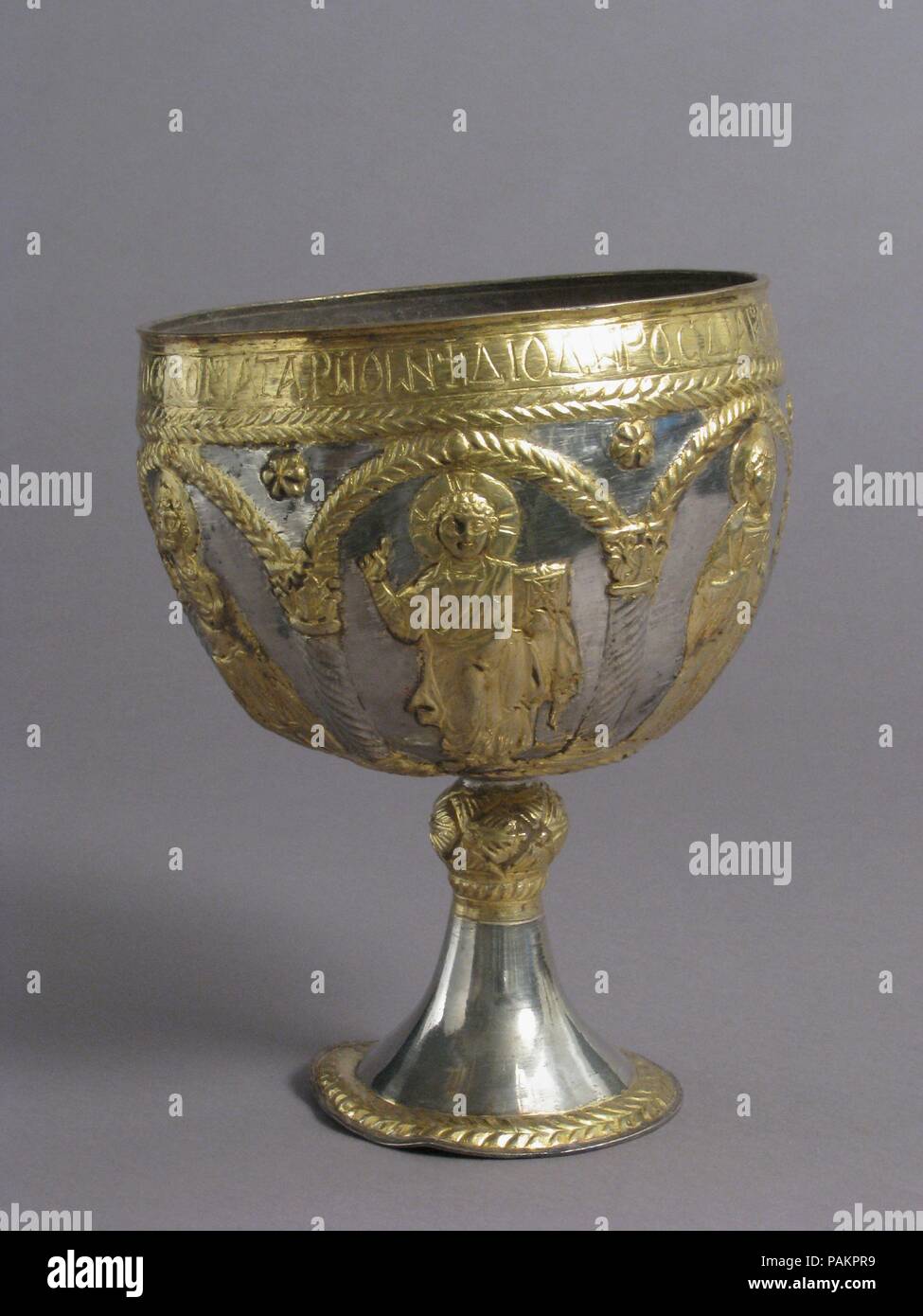 Die Attarouthi Schatz - Kelch. Kultur: Byzantinischen. Abmessungen: Insgesamt: 8 1/16 x 6 1/4 in., 12.2 oz. (20,4 × 15,9 cm, 347 g) Durchm. Der Fuß: 3 11/16 in. (9,4 cm) Durchm. von Knop: 1 5/16 in. (3.4 cm) Kapazität der Cup: 1550 ml. Datum: 500-650. Mit einem Jugendlichen Christus mit kreuzförmigen Halo flankiert von einem Diakon saint Holding ein Evangelium Buch (?) und ein Heiliger mit Personal und Schild, und die Jungfrau Maria in orant Pose von Erzengel flankiert, unter Arkaden in der Griechischen bezeichnet: Für die Verstorbenen der Seele von Anastasia und das Heil des Johannes, diakon von Saint Stephen des Dorfes Attarathion 1986.3.5 Th Stockfoto
