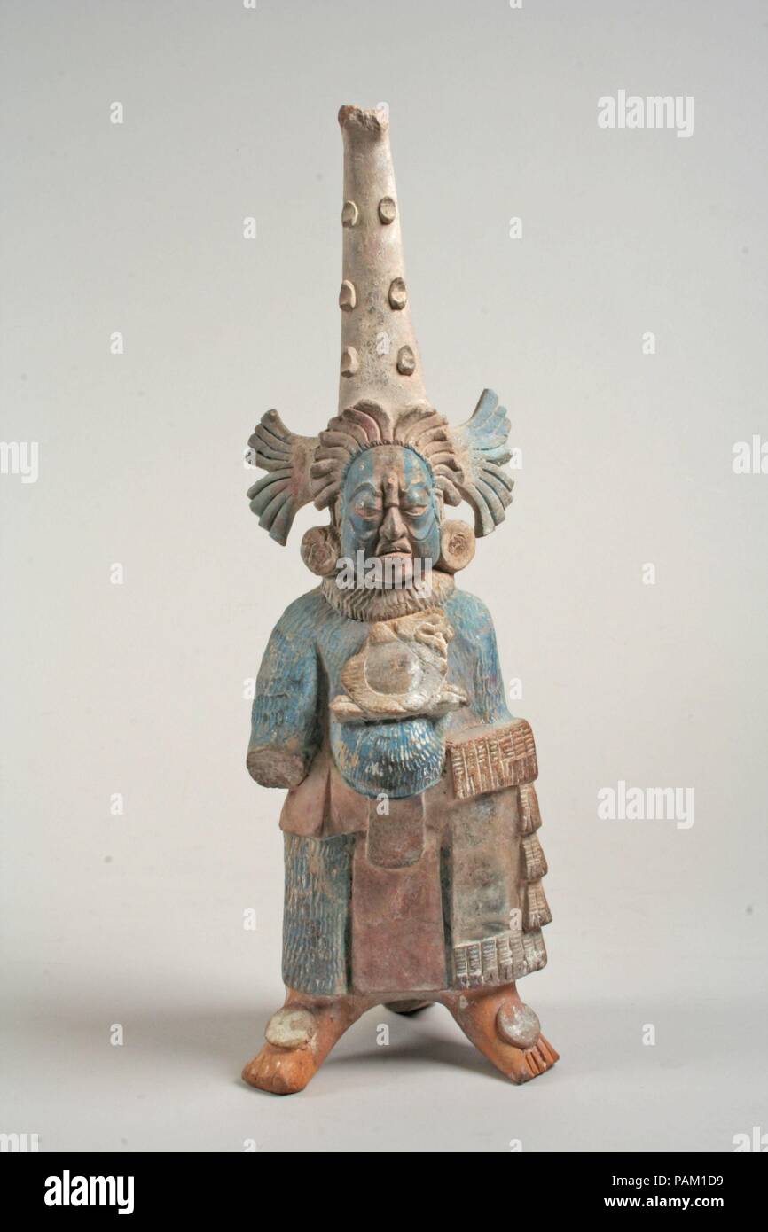 Kostümierte Figur. Kultur: Maya. Abmessungen: H. 11 1/2 x W. 3 13/16 x 3 3/4 in. (29,3 x 9,7 x 9,5 cm). Datum: 7.-8. Jh.. Diese Keramik Figur zeigt eine stehende männliche trägt einen langen strukturierten Body und konischen Kopfschmuck. Sein Mund steht offen, als ob, und er trägt ein Ornament zwischen seinen Augen. Eingeschnittenen Linien auf seinen Wangen können Falten dar, er ist eine ausgereifte Einzelnen. Er trägt einen Riemen und Lendenschurz über dem Strampler sowie eine gerafftem Kragen und große runde earflares oder Ornamente in den Ohrläppchen getragen (siehe 1994.35. 591 a, b ein Beispiel für eine earflare und Stockfoto