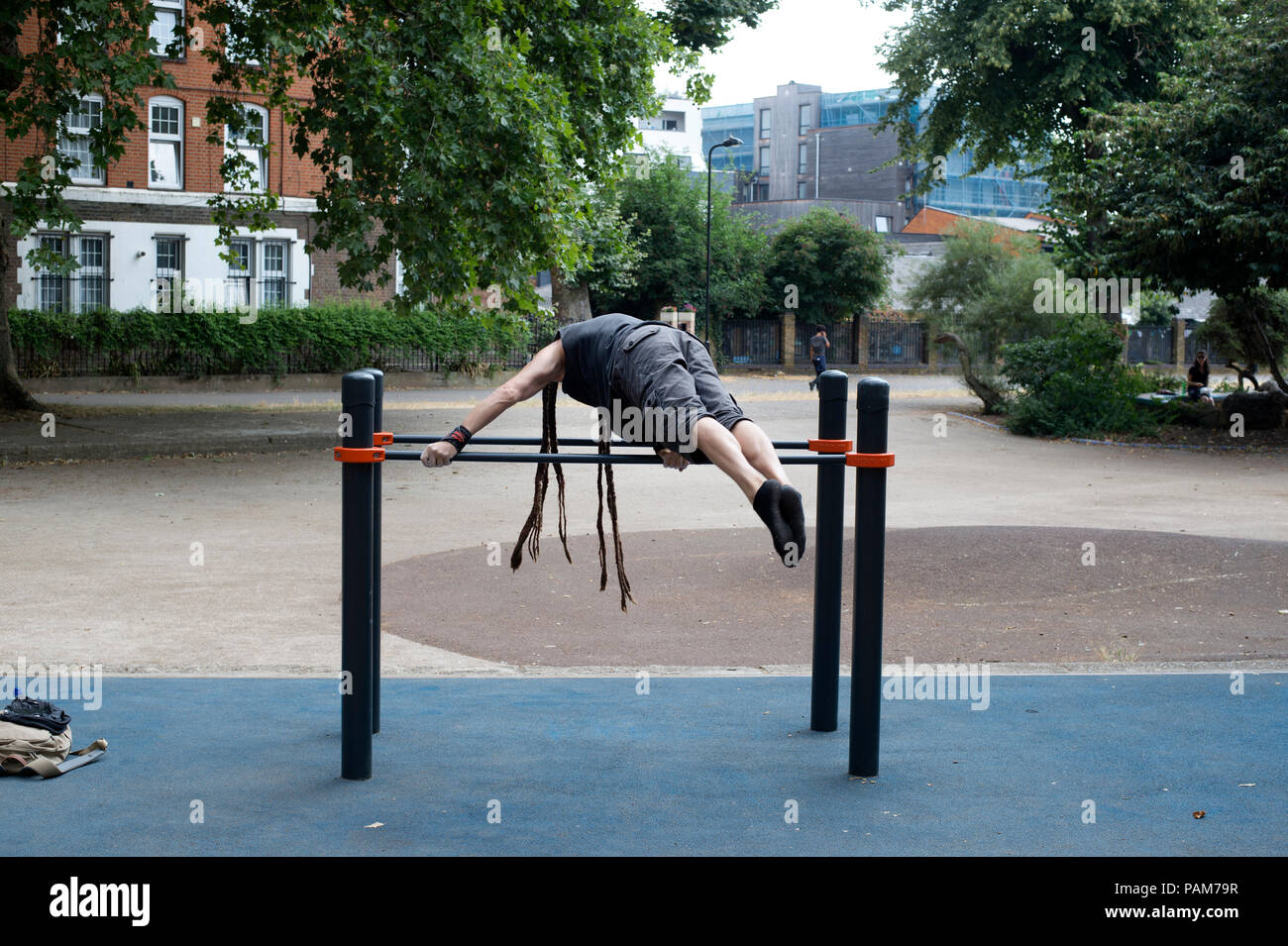 Hackney, London. Junger Mann mit Dreadlocks hat ups auf Parallele Stangen schieben Stockfoto