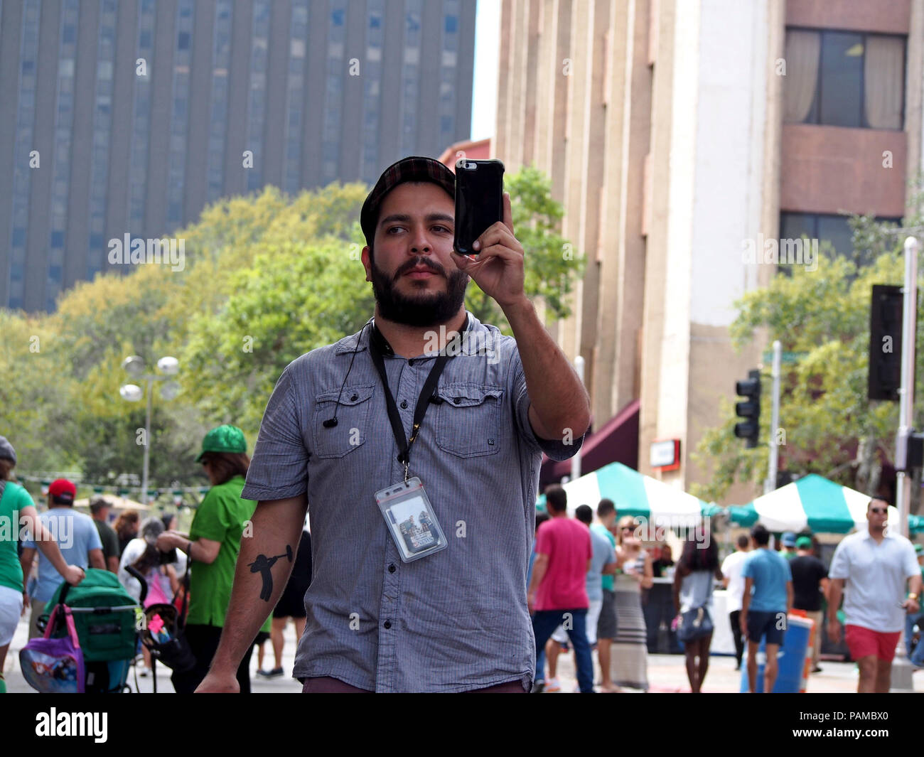 Der Fotojournalist aus einer lokalen Nachrichtenagentur rastet ein Foto mit seinem Handy am St. Patrick's Day Block Festival in Corpus Christi, Texas USA. Stockfoto