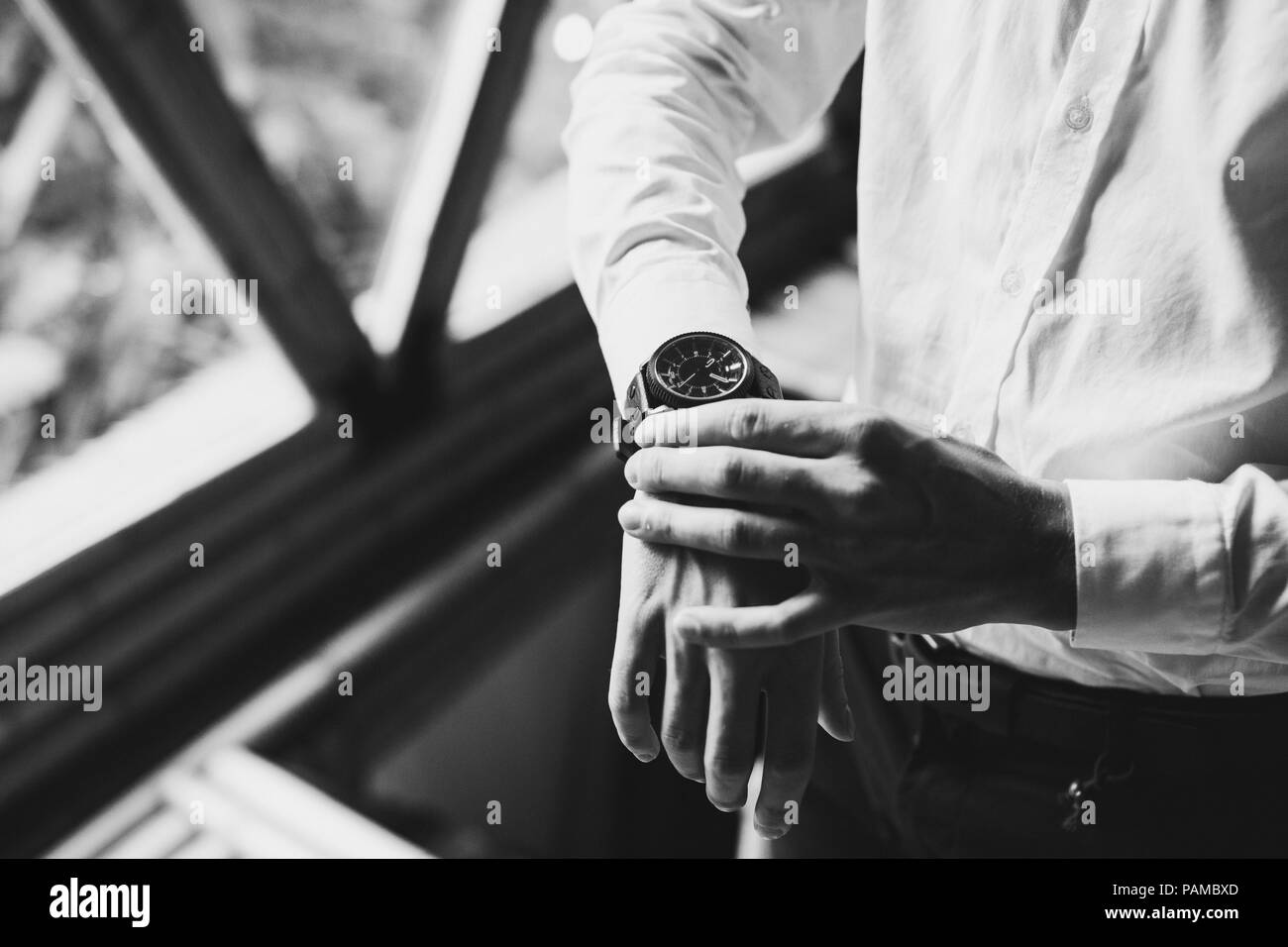 Mann im weißen Hemd mit schwarzen Uhren. Schwarz-weiß Stil Foto Stockfoto
