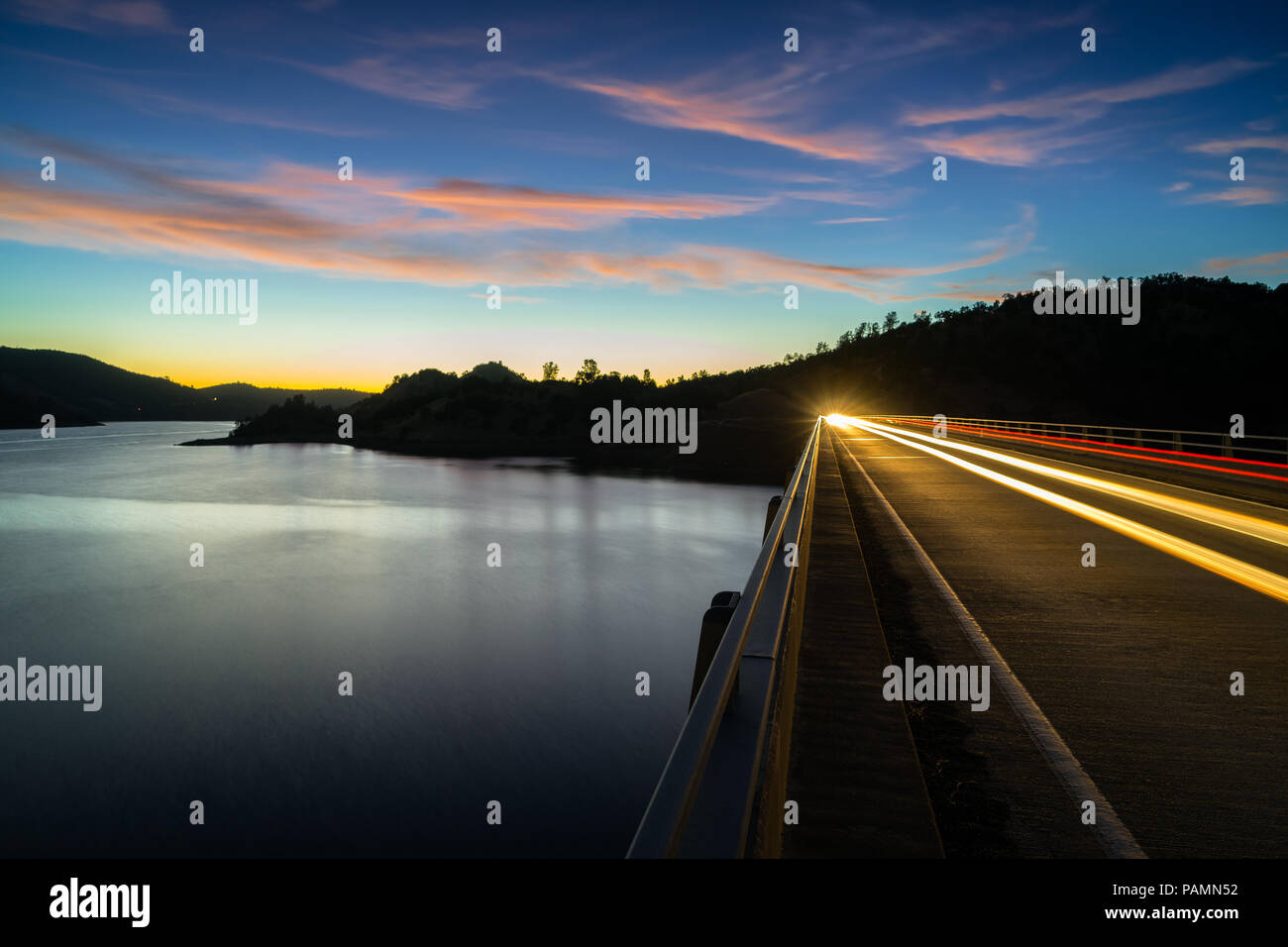 Rosa Wolken und Scheinwerfer Wanderwege über die glatte Wasser von Don Pedro Behälter und See, Sierra Vorberge - Tuolumne County, Kalifornien Stockfoto