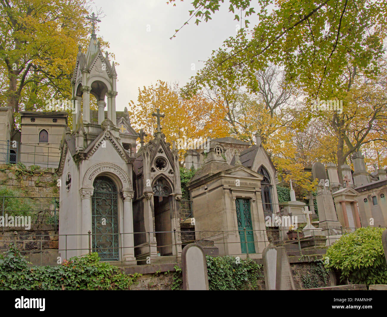 Altes Grab Denkmäler und Herbst Bäume im Friedhof von Montmartre, Paris, Frankreich. Ansicht von unten Stockfoto