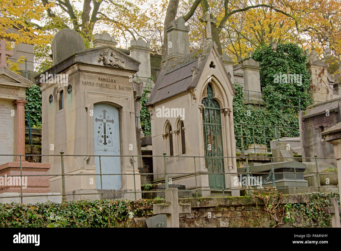 Altes Grab Denkmäler und Herbst Bäume im Friedhof von Montmartre, Paris, Frankreich. Ansicht von unten Stockfoto