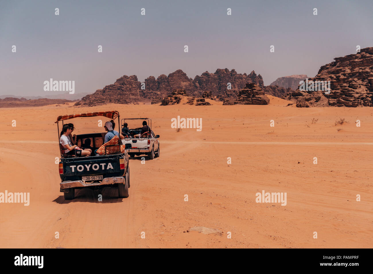 Abholung tricks voller Touristen fahren im Konvoi über die rote Wüste Sand in der berühmten Nationalpark Wadi Rum, Jordanien Stockfoto