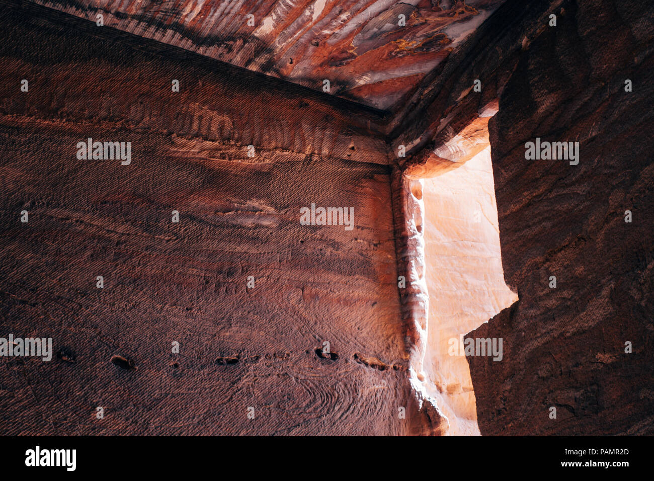 Eine geschnitzte Fenster können nachmittags Licht in einem Grab, die Schichten von Rot und Weiß in der verlorenen Stadt Petra Stockfoto