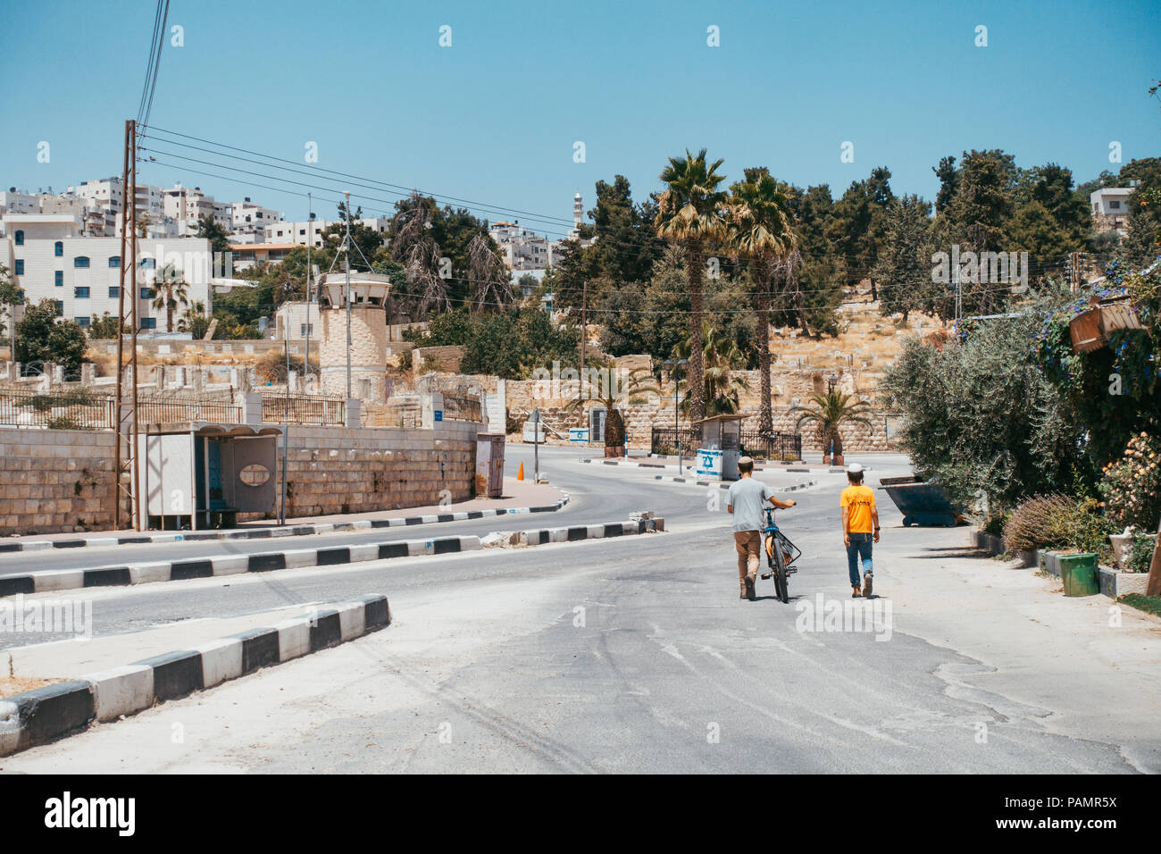 Zwei junge jüdische Jungen Rad Fahrrad in eine leere Straße in einer Siedlung in Hebron, West Bank Stockfoto