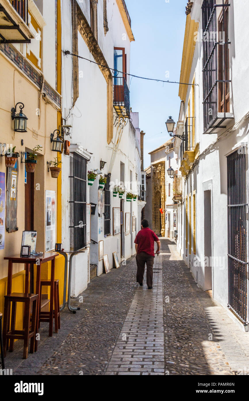 Arcos de la Frontera, Spanien - 22. Juni 2018: Der Mann, der zu Fuß einer schmalen Straße. Die meisten Straßen sind ungeeignet für Fahrzeuge. Stockfoto