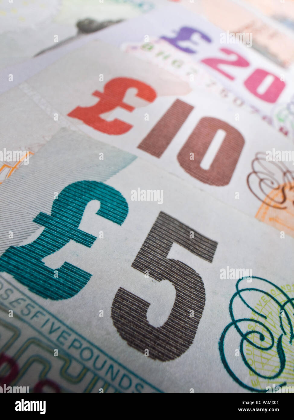 Close-up zeigt britische Bank Notes in einer Linie. Selektiver Fokus auf die fünf Pfund. Stockfoto