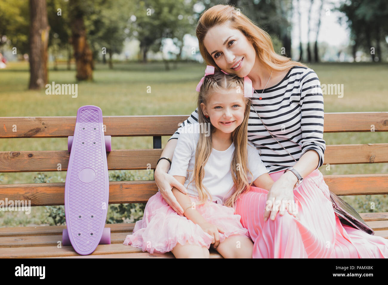 Blonde Mutter und Tochter sitzt auf der Bank im Park Stockfoto