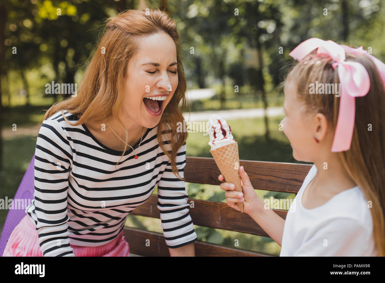 Blonde Funny Girl Eis essen mit ihrer Mutter Stockfoto