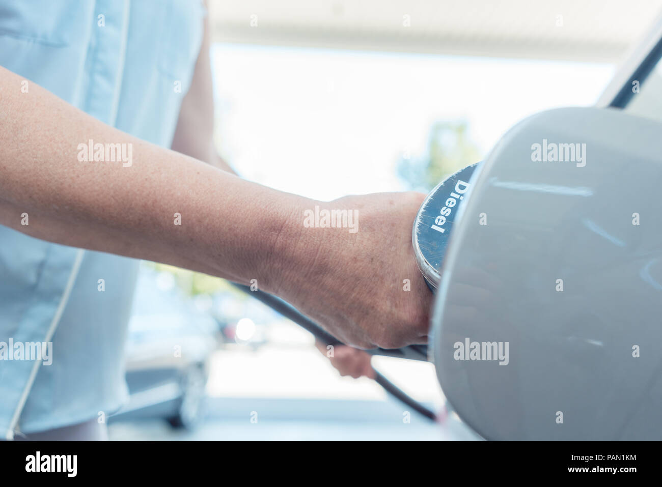 Nahaufnahme der Hand einer älteren Frau füllt den Tank Ihres Autos Stockfoto