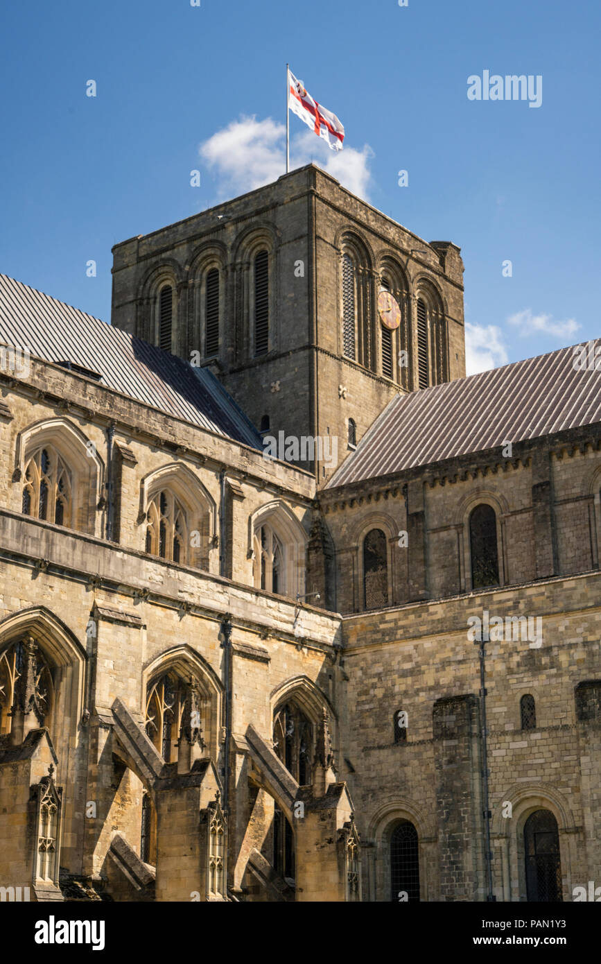 Kathedrale von Winchester aus auf dem Gelände an der St Georges Cross Flag von England nach oben auf dem Turm. Stockfoto