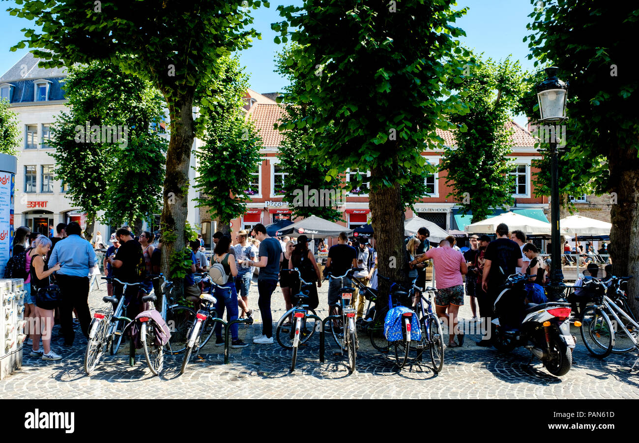 Menschen Schutz vor der heißen Mittagssonne und ihre Mobiltelefone im Zentrum von Brügge, Belgien verwenden Stockfoto